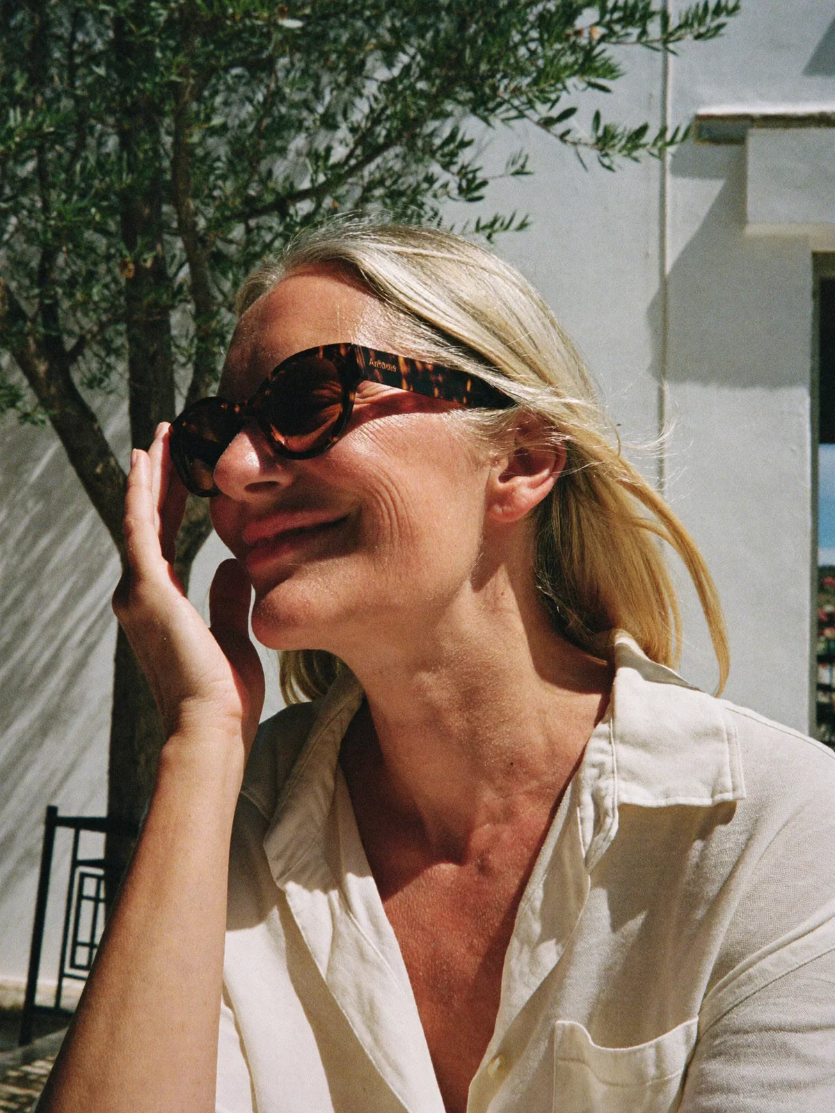 Woman in a relaxed ivory linen shirt at a Greek cafe